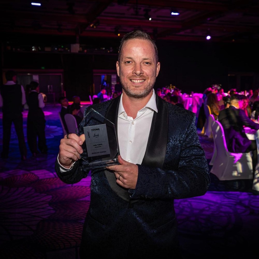 Luke Tadich holding the Young Entrepreneur Awards trophy